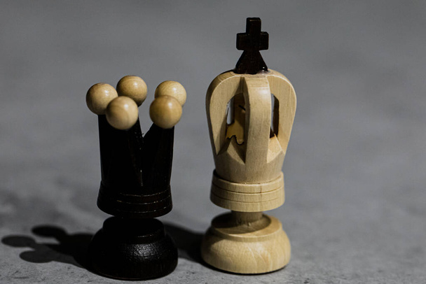 Schachfiguren Weißer König und Schwarze Königin stehen gemeinsam auf grauem Tisch - Foto, Bild