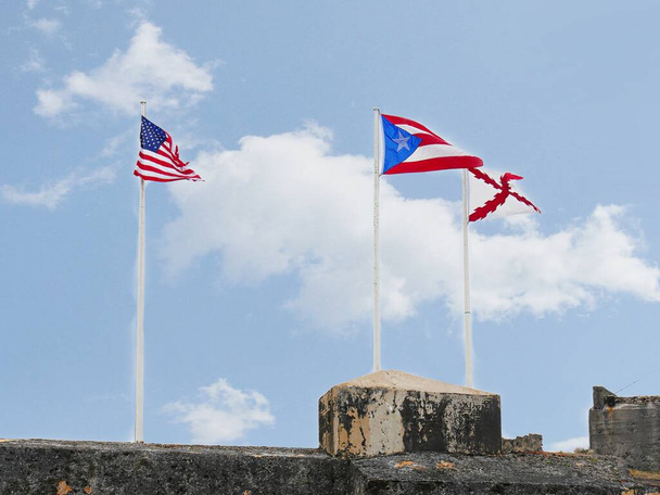Flaggen der Vereinigten Staaten und Puerto Ricos wehen über Castillo San Felipe del Morro oder El Morro Fort in San Juan, Puerto Rico. - Foto, Bild