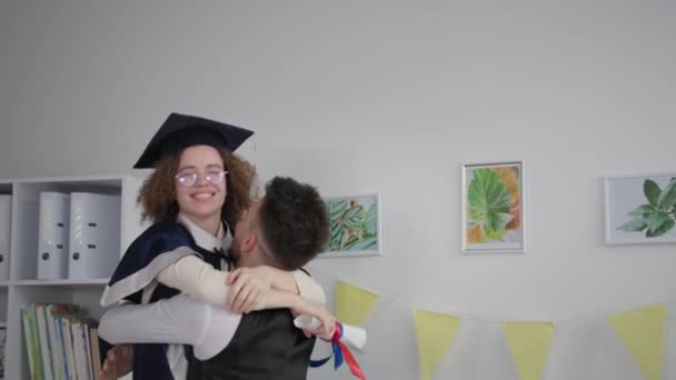 happy girl university graduate jumping into arms of guy rejoicing at training certificate - Video