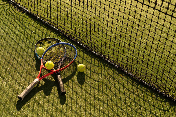 Μια ρακέτα του τένις και μια νέα μπάλα του τένις σε ένα φρεσκοβαμμένο γήπεδο τένις - Φωτογραφία, εικόνα