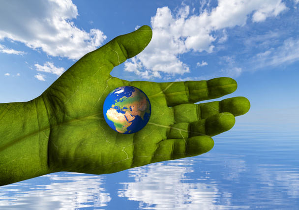 Environment Earth Day. The world turns to climate action. A hand with the texture of a green leaf supports the world - Photo, Image