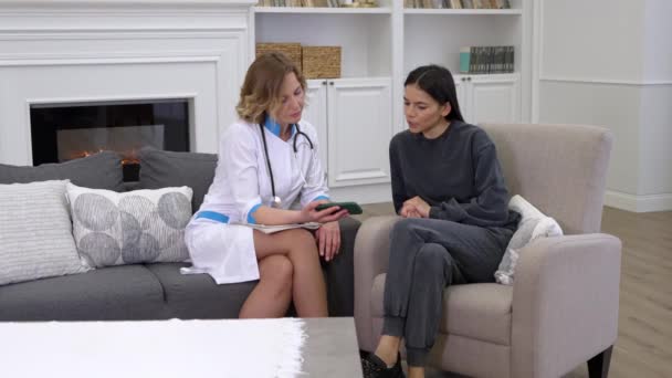 Kadın doktor hastaya sağlık hizmeti mobil uygulamasının nasıl kullanılacağını gösteriyor - Video, Çekim