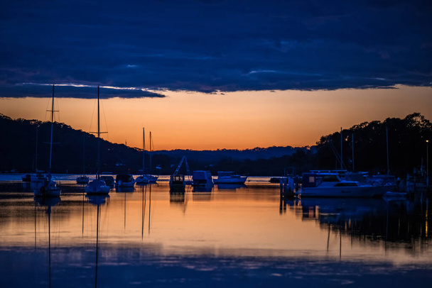 Shades of dawn with boats at the waterfront in Woy Woy on the Central Coast, NSW, Australia. - Photo, image