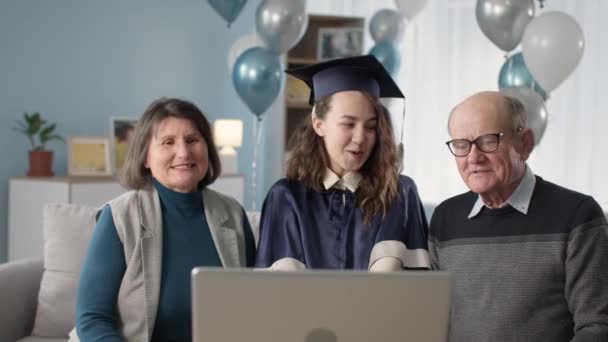 online graduation ceremony, loving parents and graduate daughter celebrating graduation via video link at home - Video