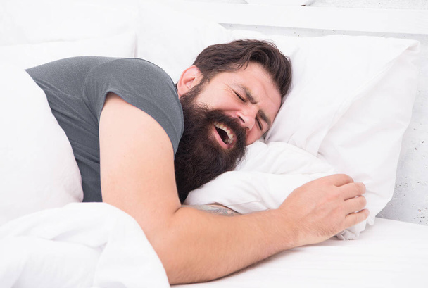 yawning bearded man feel sleepy and tired in bedroom, early morning wake up - Photo, image
