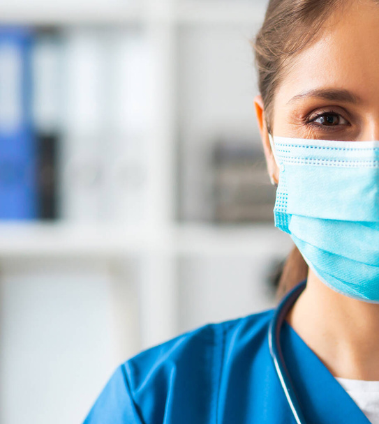 Professional medical doctor working in hospital office, Portrait of young and attractive female physician in protective mask. - Фото, зображення