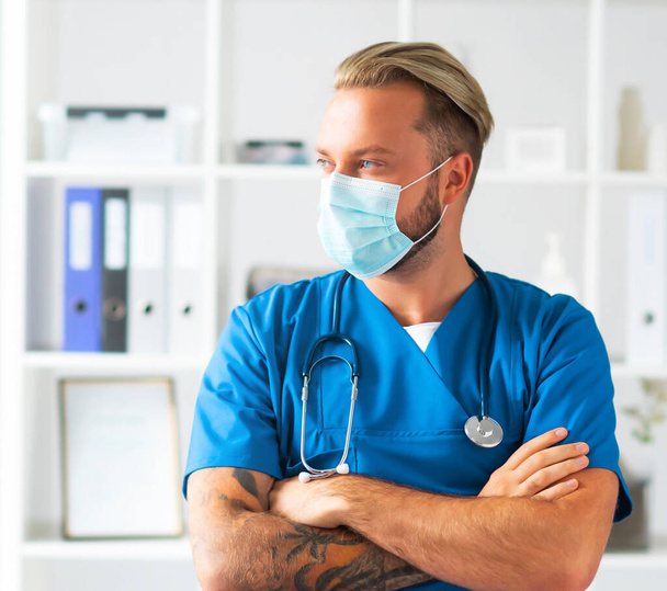 Professional medical doctor in hospital office, Portrait of young and confident physician in protective mask. - Foto, afbeelding