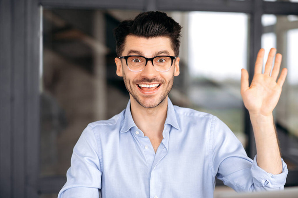 Online conference, virtual meeting. Caucasian handsome confident successful man with glasses, businessman, mentor or consultant, welcomes the interlocutor, looks at the webcam, smiles, video call - Fotoğraf, Görsel