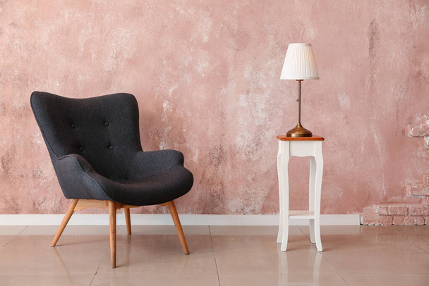 Крісло і стильна лампа біля кольорової стіни в кімнаті
 - Фото, зображення