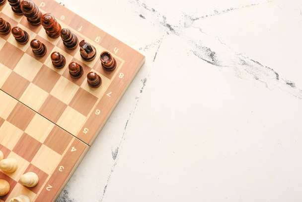 Chess pieces with game board on light background - Photo, Image