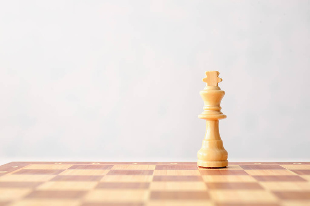 Chess board with king on white background - Φωτογραφία, εικόνα