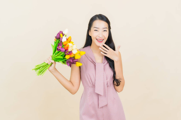 Portrait beautiful young asian woman smile with flower on color background - Foto, Imagem