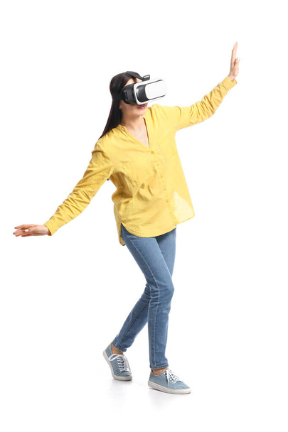 Young woman with VR glasses on white background - Foto, imagen