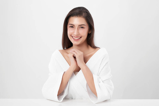 Красива азіатка, одягнена в халат на білому тлі, догляд за обличчям, лікування, косметологія, краса і спа Концепція. - Фото, зображення
