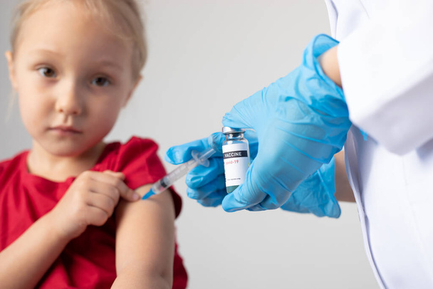 The doctor gives the child an injection of covid-19 vaccine. - Fotografie, Obrázek