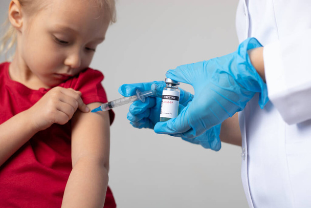 The doctor gives the child an injection of covid-19 vaccine. - Valokuva, kuva