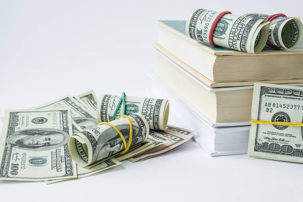 Knowledge leads to wealth. Stack of books with dollars. Concept of expensive education. Money in books. Saving money for college univercity. Savings, paid tuition - Photo, Image