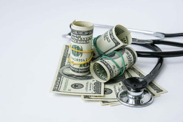 Rahakasa rahaa ja stetoskooppi. Käsite lääketieteen kallis lääketiede, lääkärit palkka. Kopioi tilaa tekstille. Sairausvakuutus. rokotuskustannukset. Rahoituskriisi. Covid-19 rikokset - Valokuva, kuva