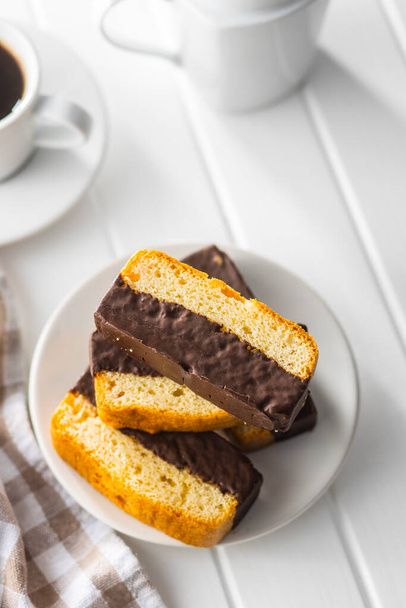 Sliced sponge dessert. Sweet sponge cake with chocolate on white table. - Photo, Image
