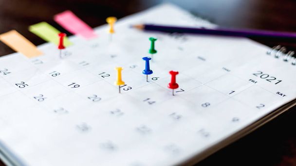 Zamknij kalendarz na brązowym stole w planowaniu pomysłów. - Zdjęcie, obraz