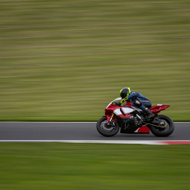 Una toma panorámica de una moto de carreras mientras circula una pista. - Foto, imagen