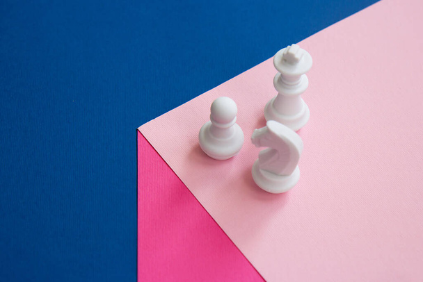 Белые шахматные фигуры на кубе. Пешка, шахматный рыцарь и шахматная королева на ярком фоне. Концепция командной работы. Абстрактный фон - Фото, изображение