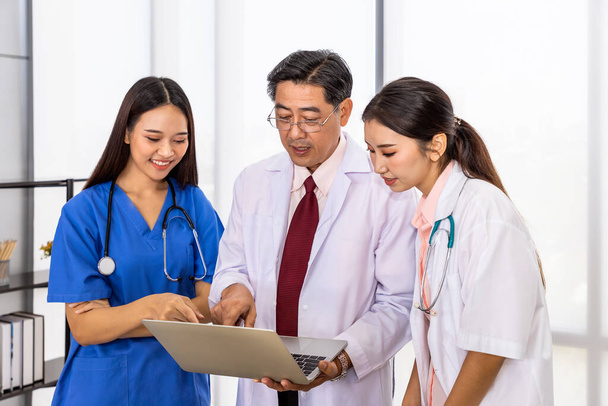 Щасливої азіатської чоловічої і жіночої медичної команди стоячи і зустрічаючи обговорення про вакцину ноутбуком - Фото, зображення