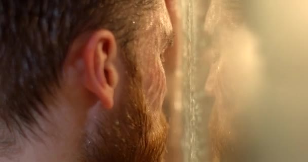 Portrait of the desperate handsome man with depression and gigner beard suffering in the shower. - Footage, Video