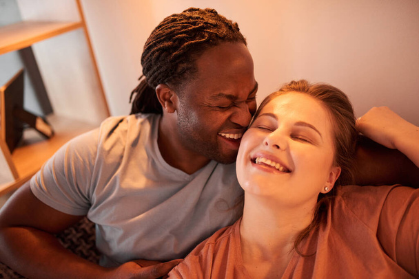 Man with dreadlocks laughing and bonding to his lovely caucasian wife - Fotografie, Obrázek
