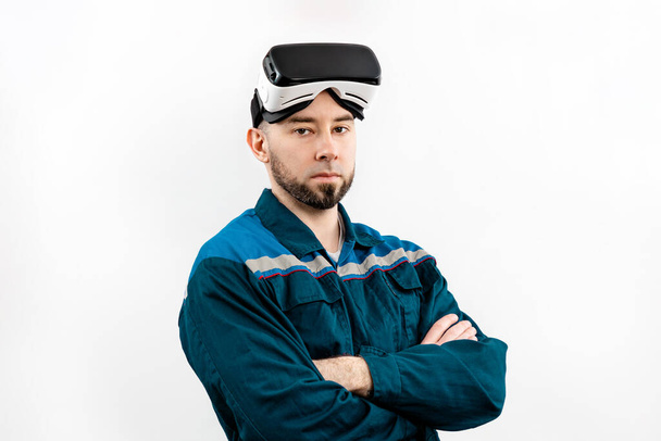 Portrét dospělého muže v brýlích virtuální reality, pracovní uniforma, ruce zkřížené. Izolované na bílém pozadí. Koncept využití virtuální reality v práci. - Fotografie, Obrázek