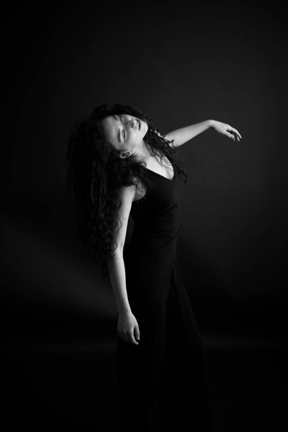 Fashion portrait of a dancer in a black classic dress. - Foto, imagen
