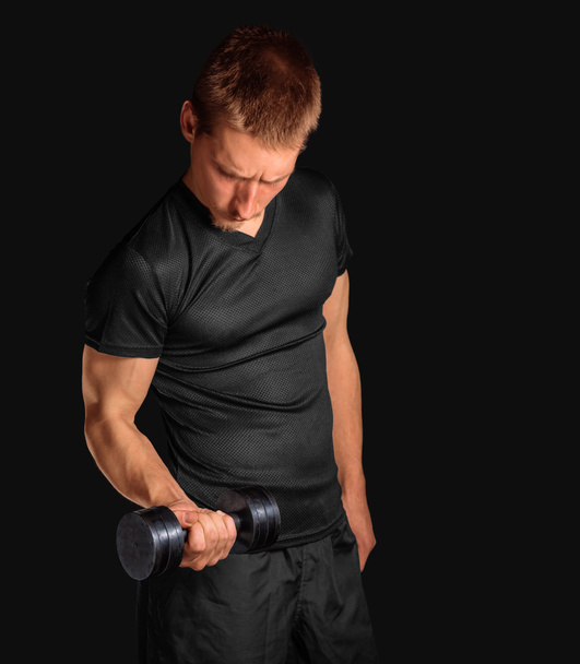 Man exercises with dumbbell - 写真・画像