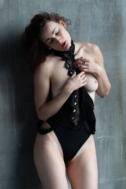 jovem bela mulher posando em preto bodysuit no estúdio - Foto, Imagem