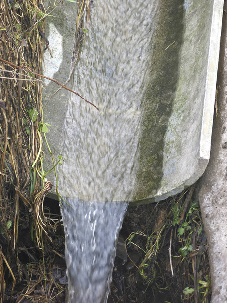 l'eau coule d'une goulotte de fer au printemps - Photo, image