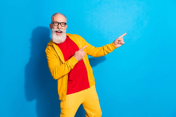 Photo of happy excited good mood mature man point finger copyspace advertisement isolated on blue color background - Fotó, kép