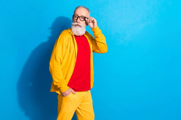 Photo of serious cool confident handsome mature man in glasses look copyspace go walk isolated on blue color background - Fotó, kép