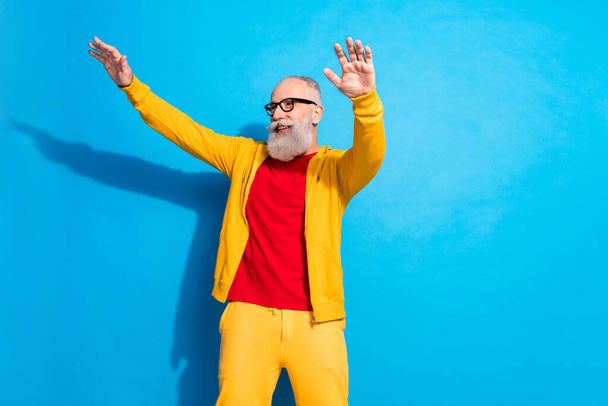 Photo of happy excited good mood funky funny mature man dancing look copyspace isolated on blue color background - Fotó, kép