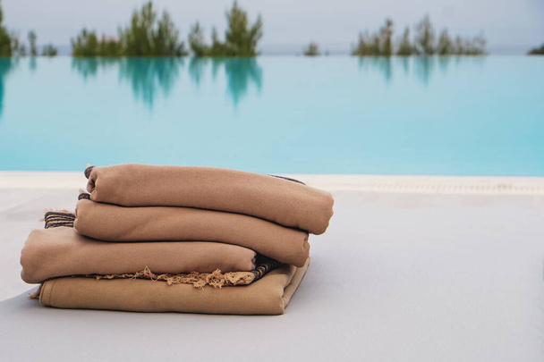 Stack of fresh clean pool towels near the swimming pool. - Photo, image