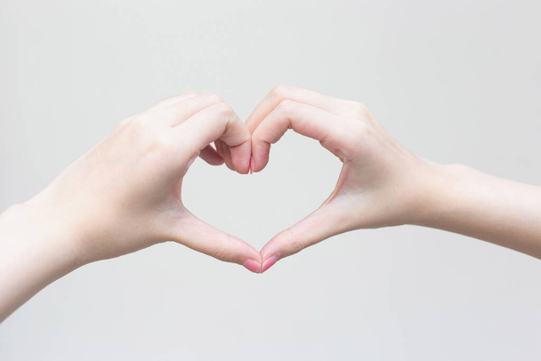 Bella mano femminile mostra il simbolo del cuore come segno d'amore nel concetto di manicure. - Foto, immagini