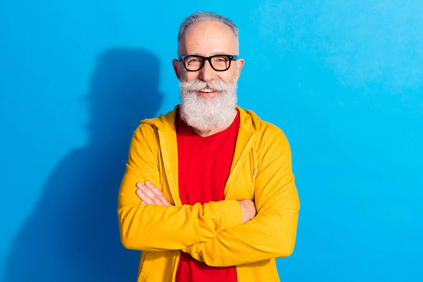 Photo of mature happy cheerful smiling handsome businessman in glasses folded arms isolated on blue color background - Фото, зображення