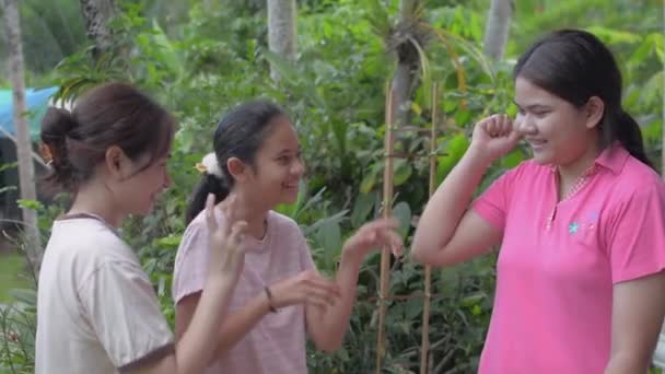 Three cheerful Thai teen sisters in casual dress enjoy to play together at home. Asian sibling. Bonding relationship in family. Diverse teenager. - Footage, Video