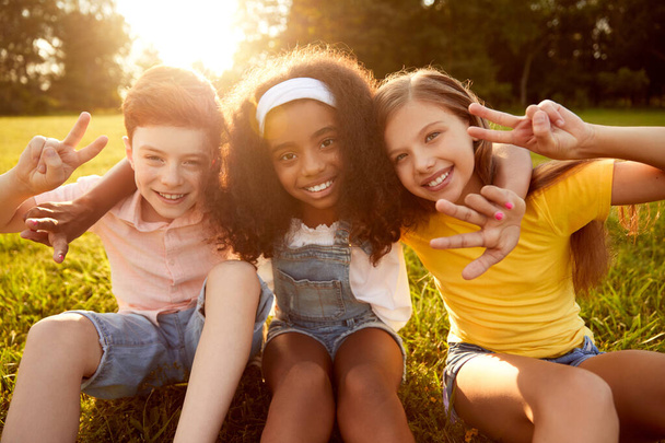 Group of multiracial kids embracing together in park - Foto, Bild