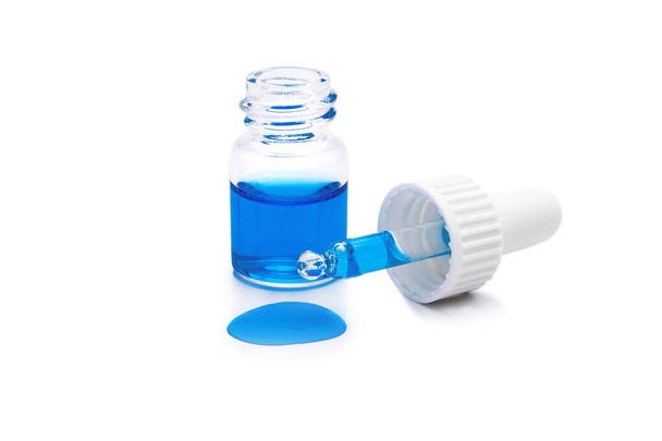 glass bottle with pipette and spilled blue liquid isolated on white background - Φωτογραφία, εικόνα