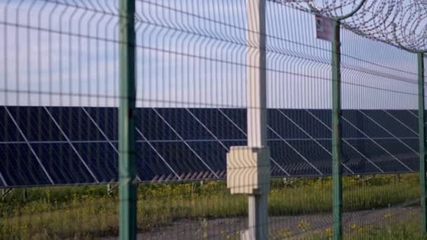Солнечные панели ограждены оградой из колючей проволоки. Солнечные батареи. 4K - Кадры, видео