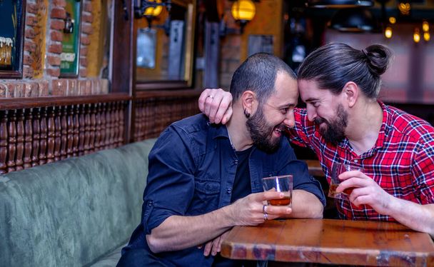 Dos amigos varones bebiendo whisky juntos en el pub. Están borrachos y hablan, se abrazan y se reconfortan. De vuelta a la vida normal. Copiar espacio. - Foto, Imagen