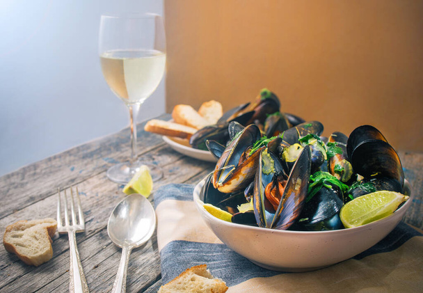 Blue mussles with vine and baguette on wooden table - Photo, Image