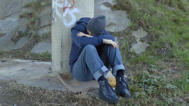 Cansada mujer adicta solitaria se sienta debajo del puente - Metraje, vídeo