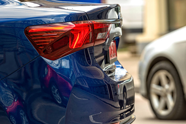 rear half with rear lights of a parked car on the side of the street, vehicle exterior details, closeup - Foto, immagini