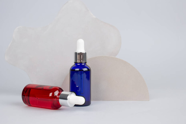 Mockup image of dropper bottle with modern organic cosmetics - polyglutamic or hyaluronic acid, serum, moisturizer, facial anti-aging oil. Trendy still life composition - 写真・画像