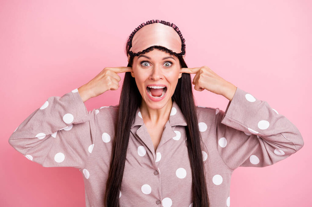 Photo of angry annoyed young lady nightwear mask fingers close ears shouting isolated pink color background - Photo, image